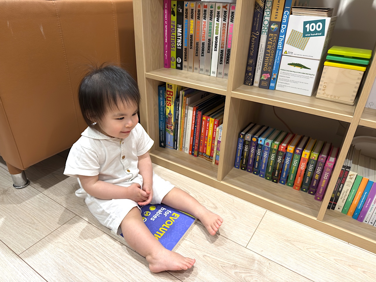 Sitting proudly with her favorite: Evolution for Babies.